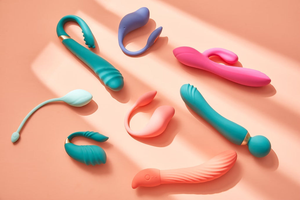 Colorful collection of beginner-friendly vibrators and adult toys displayed on a peach background – TruLuv Novelties sex toy guide.